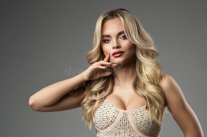 Bella chica con peinado rubio ondulado y labios perfectos maquillan. retrato de mujer de moda con uñas beige y cabello rubio suave foto de archivo libre de regalías