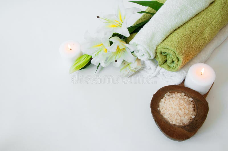 Bella composizione nella stazione termale con i fiori, gli asciugamani, il sapone, il sale da bagno e le candele del giglio immagine stock libera da diritti Bella composizione nella stazione termale con i fiori, gli asciugamani, il sapone, il sale da bagno e le candele del giglio immagine stock libera da diritti
