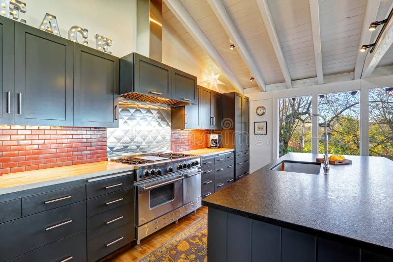 Bella cucina moderna scura di lusso con il soffitto di legno arcato fotografie stock Bella cucina moderna scura di lusso con il soffitto di legno arcato fotografie stock
