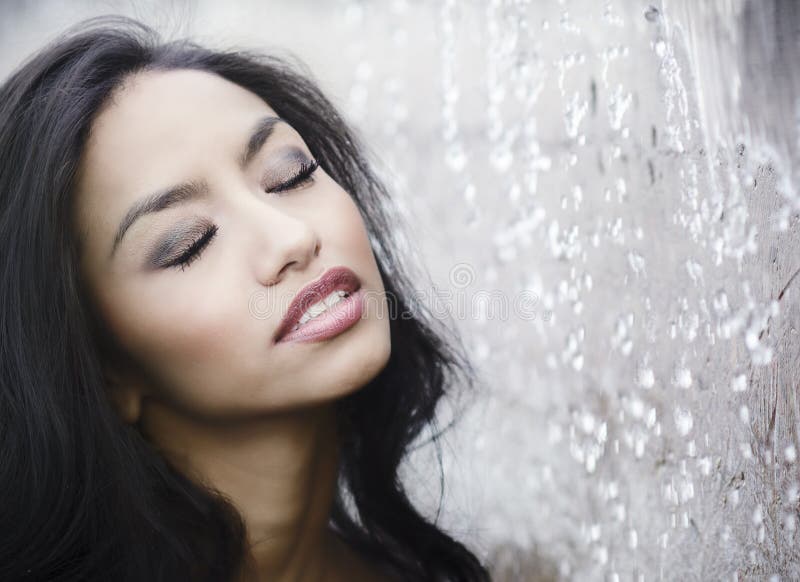 Beautiful woman standing beside pure water as it splashes around her face. Beautiful woman standing beside pure water as it splashes around her face