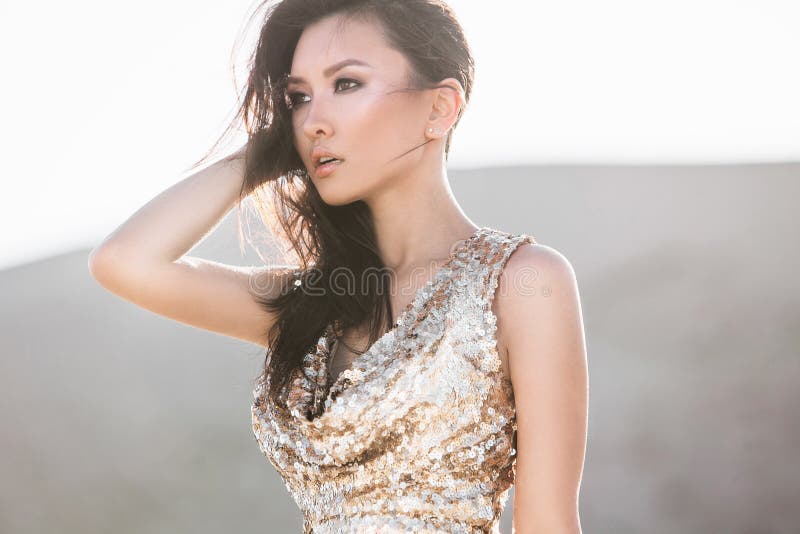 Bella donna asiatica in vestito brillante di lusso da modo in deserto fotografia stock Bella donna asiatica in vestito brillante di lusso da modo in deserto fotografia stock