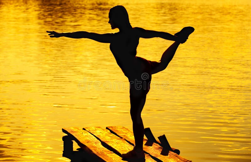 Bella, donna atletica che fa yoga sul vecchio, ponte di legno fotografia stock libera da diritti Bella, donna atletica che fa yoga sul vecchio, ponte di legno fotografia stock libera da diritti