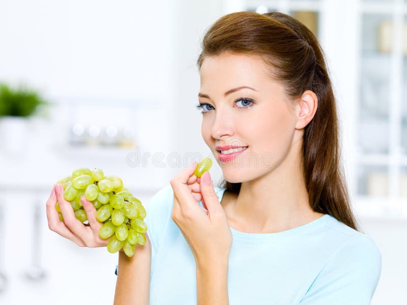 Bella donna che mangia l'uva immagini stock libere da diritti Bella donna che mangia l'uva immagini stock libere da diritti