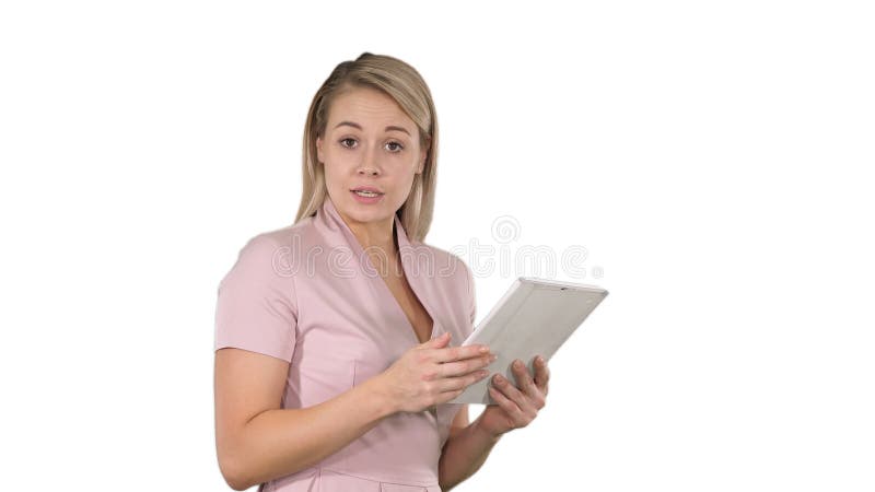 Bella donna che per mezzo di una compressa digitale e parlando con macchina fotografica su fondo bianco immagini stock Bella donna che per mezzo di una compressa digitale e parlando con macchina fotografica su fondo bianco immagini stock