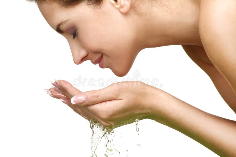 Beautiful woman refreshing her face with water on white. Beautiful woman refreshing her face with water on white
