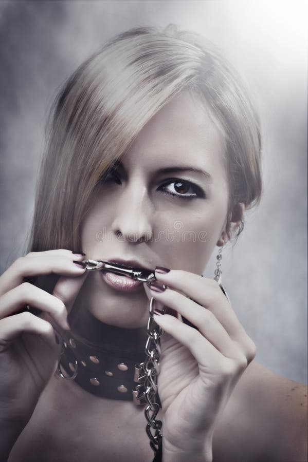Bella donna con la catena nella sua bocca immagini stock libere da diritti Bella donna con la catena nella sua bocca immagini stock libere da diritti