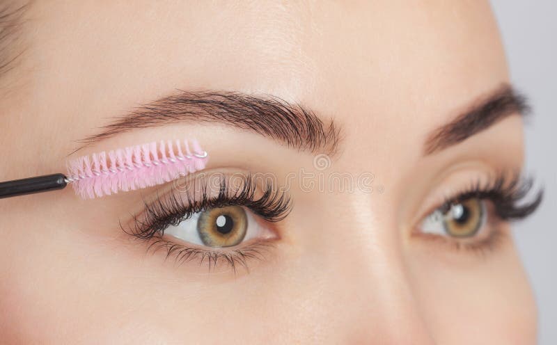 Bella donna con lunghe ciglia in un salone di bellezza Procedura di estensione per la ciellea Cosmetologia - cure cutanee