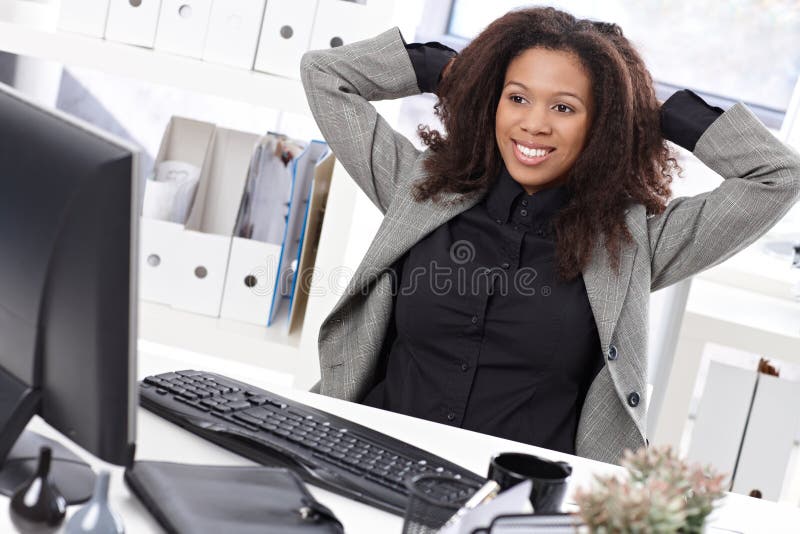 Bella donna di affari che allunga a sorridere dello scrittorio immagine stock Bella donna di affari che allunga a sorridere dello scrittorio immagine stock