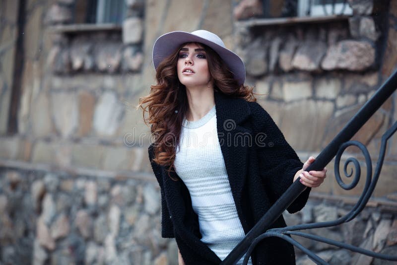 Bella donna elegante nel ove nero d'avanguardia alla moda del cappello e del cappotto fotografie stock libere da diritti Bella donna elegante nel ove nero d'avanguardia alla moda del cappello e del cappotto fotografie stock libere da diritti