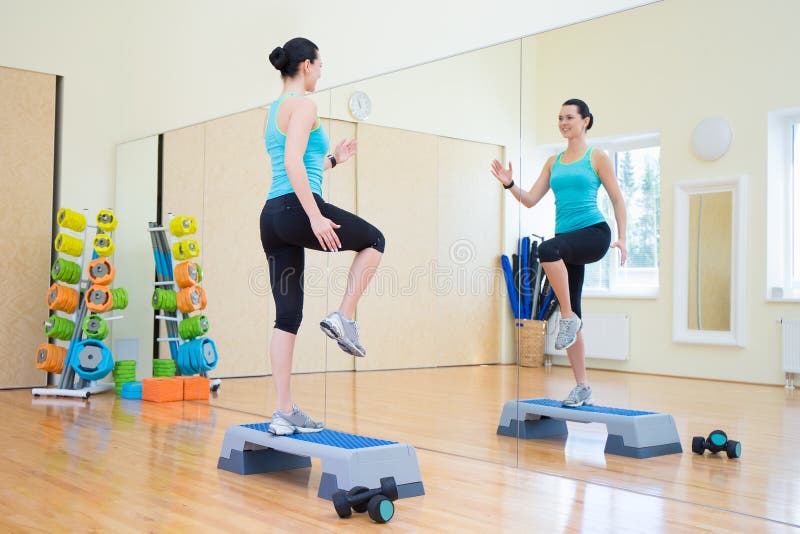 Download Bella Donna Esile Che Risolve Con Passo Passo In Palestra Fotografia Stock - Immagine di attraente, persona: 56883956