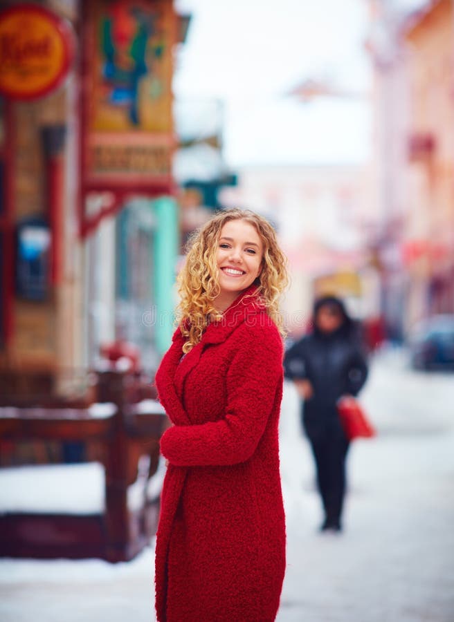 Bella donna felice che cammina sulla via ammucchiata della città nell'inverno immagini stock libere da diritti Bella donna felice che cammina sulla via ammucchiata della città nell'inverno immagini stock libere da diritti