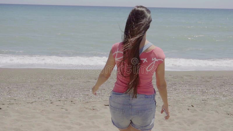 Bella donna felice che cammina vicino alla spiaggia