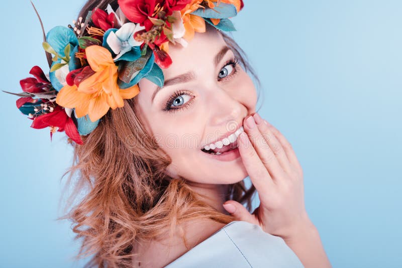 Bella donna felice in corona del fiore isolata su fondo blu Concerto della primavera fotografia stock libera da diritti Bella donna felice in corona del fiore isolata su fondo blu Concerto della primavera fotografia stock libera da diritti