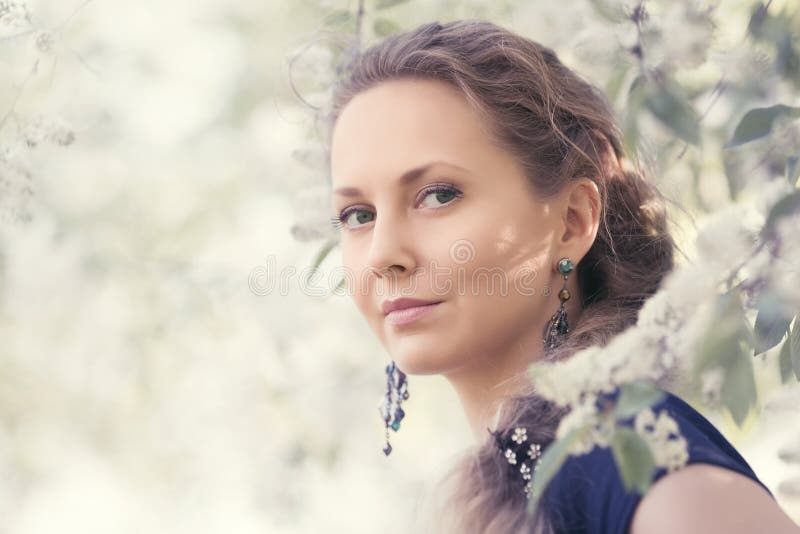 Bella donna felice di modo che cammina in un giardino della molla fotografie stock libere da diritti Bella donna felice di modo che cammina in un giardino della molla fotografie stock libere da diritti
