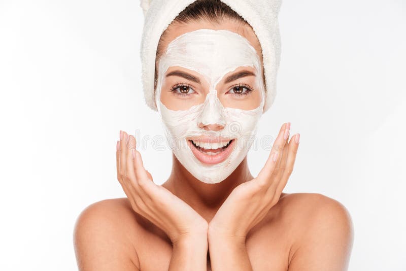 Bella donna sorridente con la maschera facciale dell'argilla bianca sul fronte immagini stock Bella donna sorridente con la maschera facciale dell'argilla bianca sul fronte immagini stock
