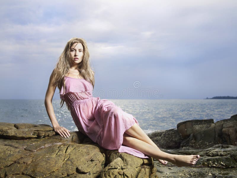 Bella donna su una spiaggia rocciosa