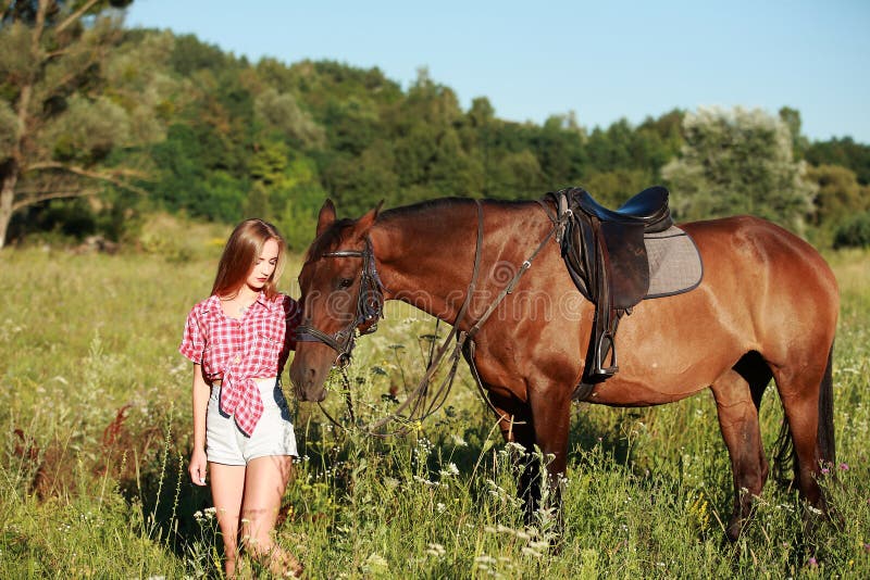Bella donna in un campo con un cavallo