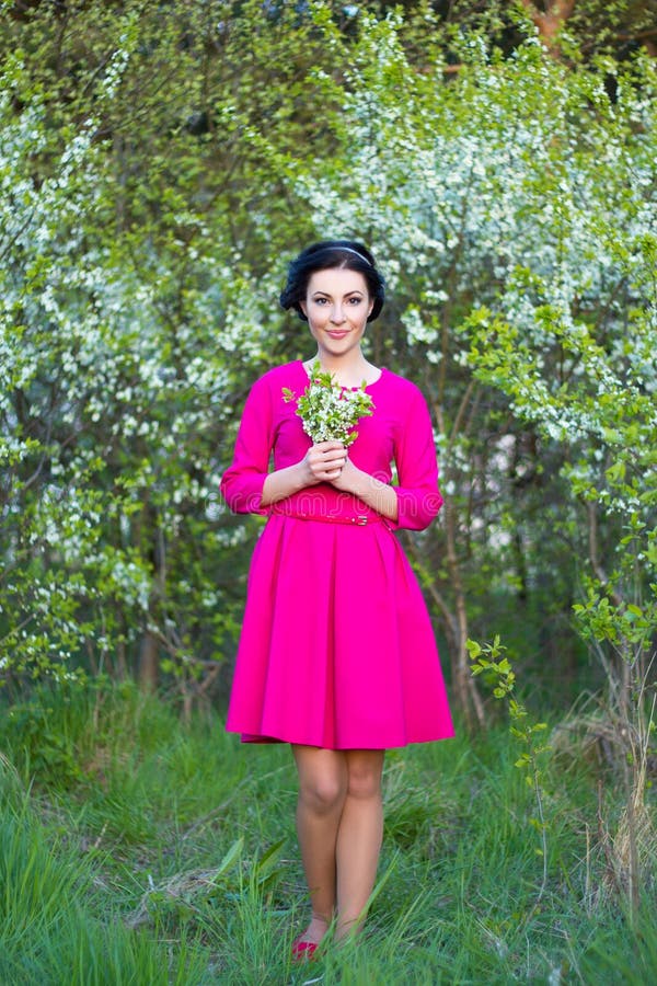 Bella donna vaga felice in vestito rosa che cammina nel che di primavera immagini stock Bella donna vaga felice in vestito rosa che cammina nel che di primavera immagini stock