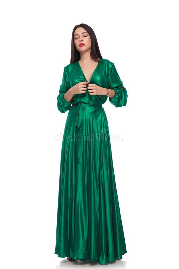 Bella donna in vestito lungo verde che sta con gli occhi chiusi immagine stock Bella donna in vestito lungo verde che sta con gli occhi chiusi immagine stock