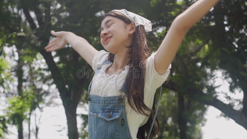 Bella giovane donna asiatica che si sente bene con allegria in estate in natura respirando fresco in vacanza in foresta.