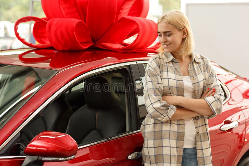 Bella giovane donna che compra nuova automobile alla gestione commerciale fotografia stock libera da diritti Bella giovane donna che compra nuova automobile alla gestione commerciale fotografia stock libera da diritti