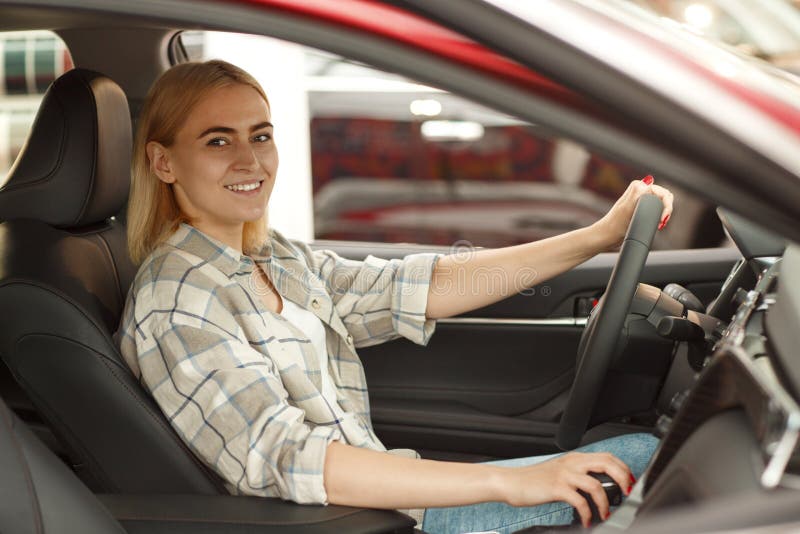 Bella giovane donna che compra nuova automobile alla gestione commerciale fotografie stock libere da diritti Bella giovane donna che compra nuova automobile alla gestione commerciale fotografie stock libere da diritti