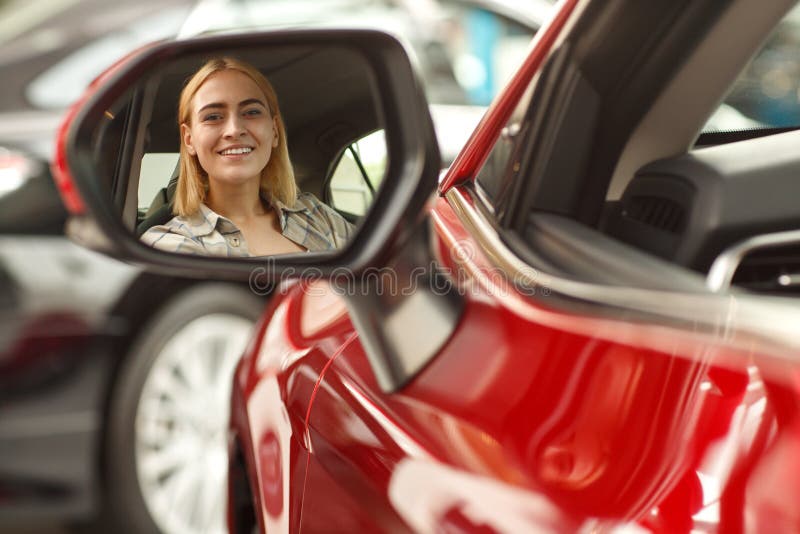 Bella giovane donna che compra nuova automobile alla gestione commerciale fotografia stock libera da diritti Bella giovane donna che compra nuova automobile alla gestione commerciale fotografia stock libera da diritti