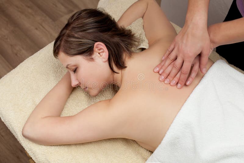 Bella giovane donna che ottiene un massaggio posteriore immagine stock libera da diritti Bella giovane donna che ottiene un massaggio posteriore immagine stock libera da diritti