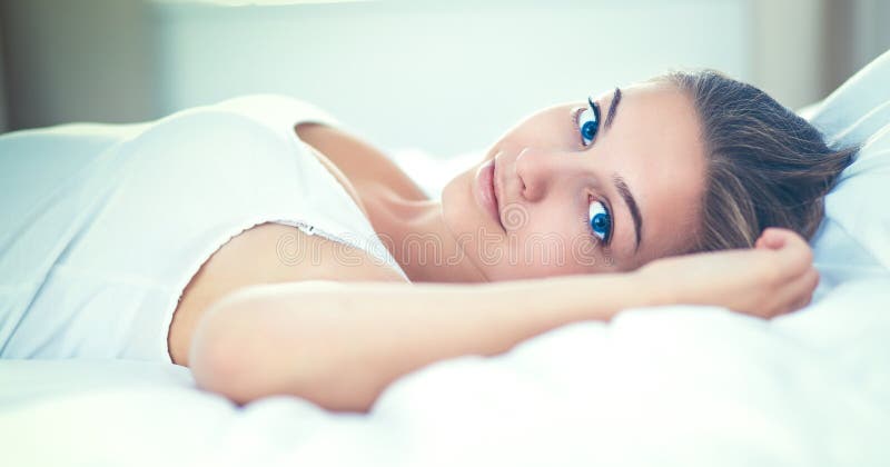 Bella giovane donna che si trova a letto confortevolmente e beato immagine stock Bella giovane donna che si trova a letto confortevolmente e beato immagine stock