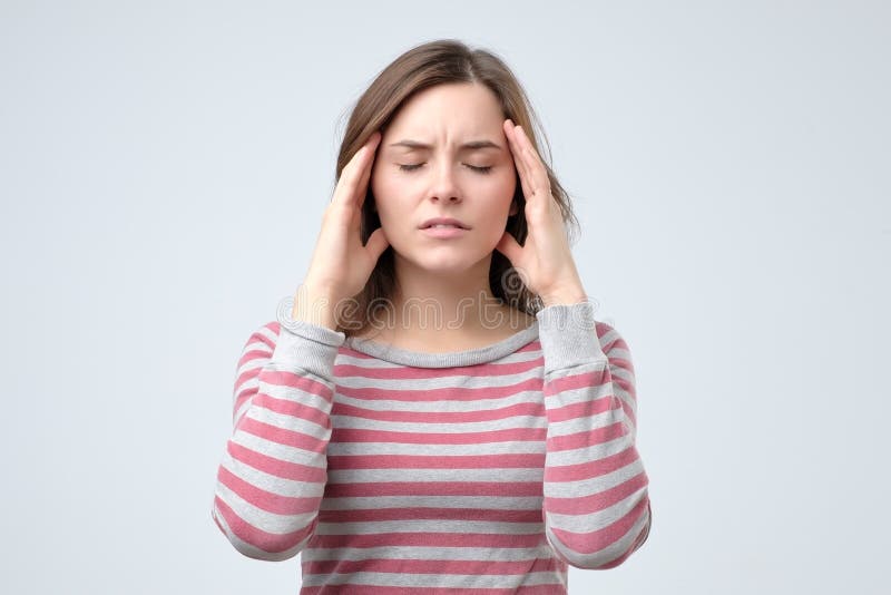 Bella giovane donna che tocca le sue tempie che ritengono sforzo o emicrania immagini stock libere da diritti Bella giovane donna che tocca le sue tempie che ritengono sforzo o emicrania immagini stock libere da diritti