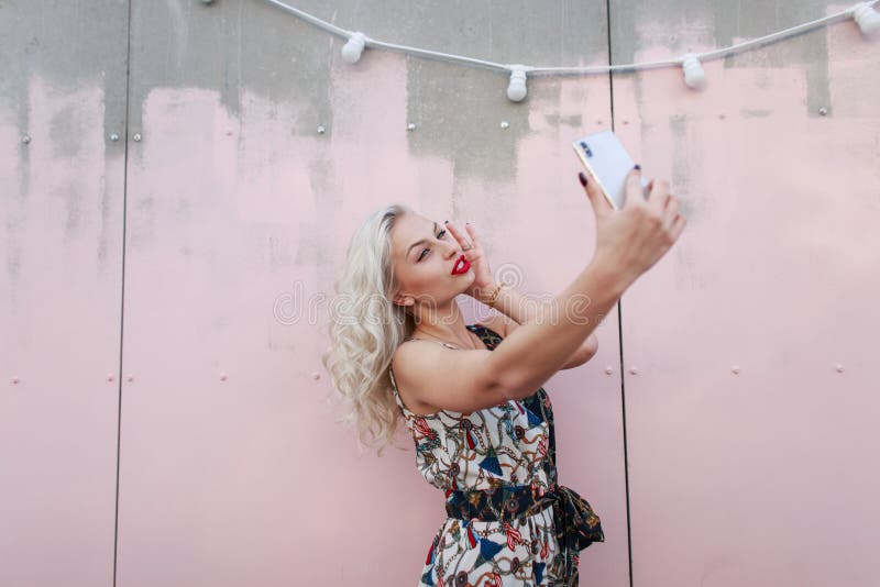 Bella giovane donna dei pantaloni a vita bassa in vestito alla moda che fa selfie fotografia stock Bella giovane donna dei pantaloni a vita bassa in vestito alla moda che fa selfie fotografia stock