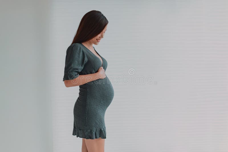 Bella Joven Embarazada Mujer Asiática Mirando Hacia Su Vientre Para Una  Sesión Fotográfica De Maternidad Con Vestido Verde. Embara Foto de archivo  - Imagen de embarazo, maternidad: 246219738