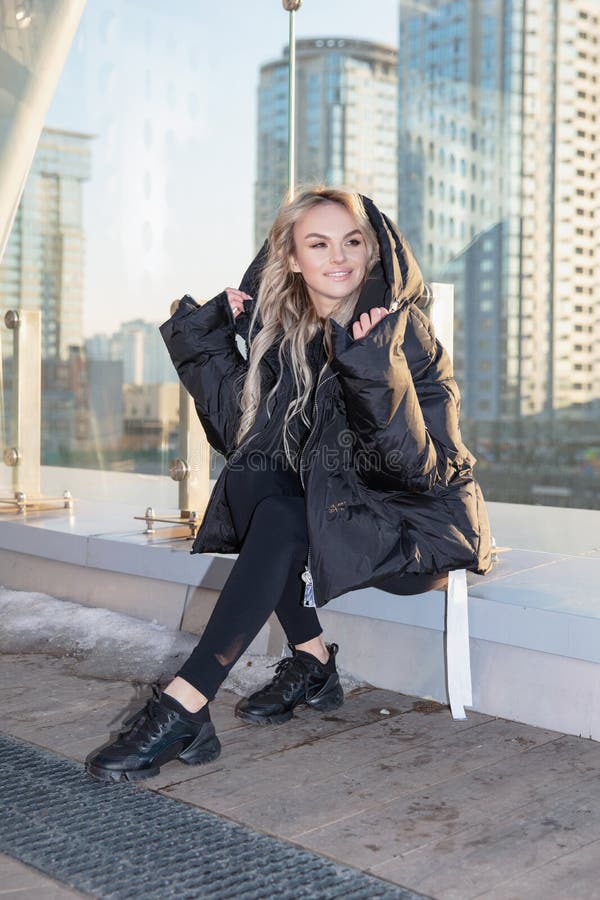 Bella joven rubia vestida con una abrigada chaqueta y pantalones imágenes de archivo libres de regalías