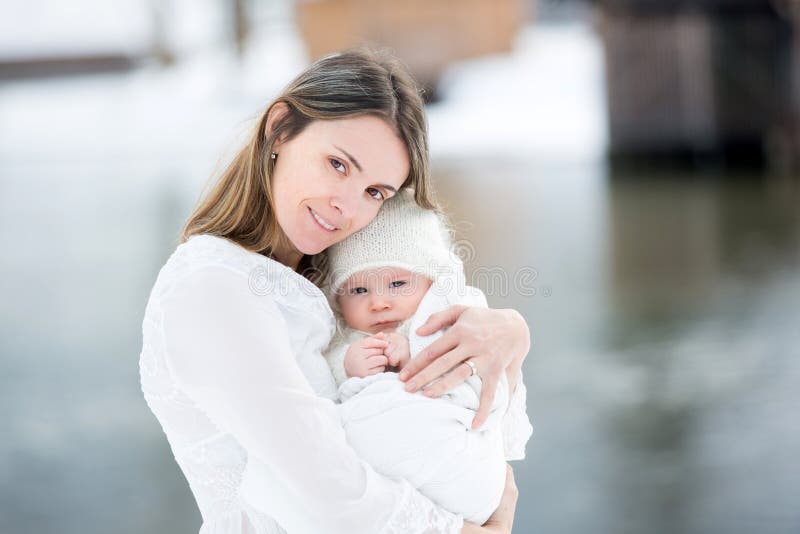 Bella madre in vestito bianco ed in neonato sveglio in quello tricottato immagine stock libera da diritti Bella madre in vestito bianco ed in neonato sveglio in quello tricottato immagine stock libera da diritti