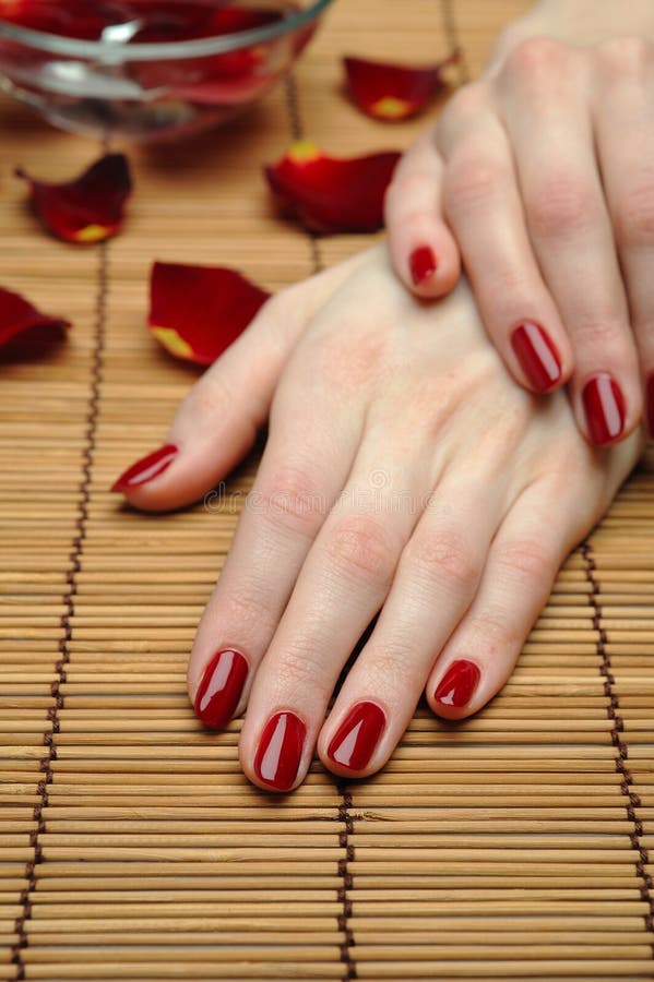Beautiful hand with perfect nail red manicure and rose petals. Beautiful hand with perfect nail red manicure and rose petals.