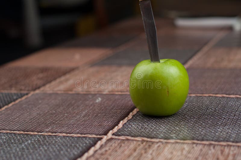 Bella mela verde con il coltello sul tavolo da cucina Frutta verde fotografie stock libere da diritti Bella mela verde con il coltello sul tavolo da cucina Frutta verde fotografie stock libere da diritti