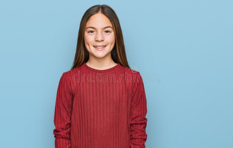 Bella morena pequeña niña con suéter casual con una sonrisa alegre y fresca en la cara foto de archivo libre de regalías