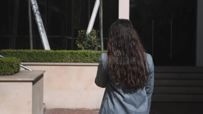 Bella mujer caminando por la calle y hablando por teléfono.