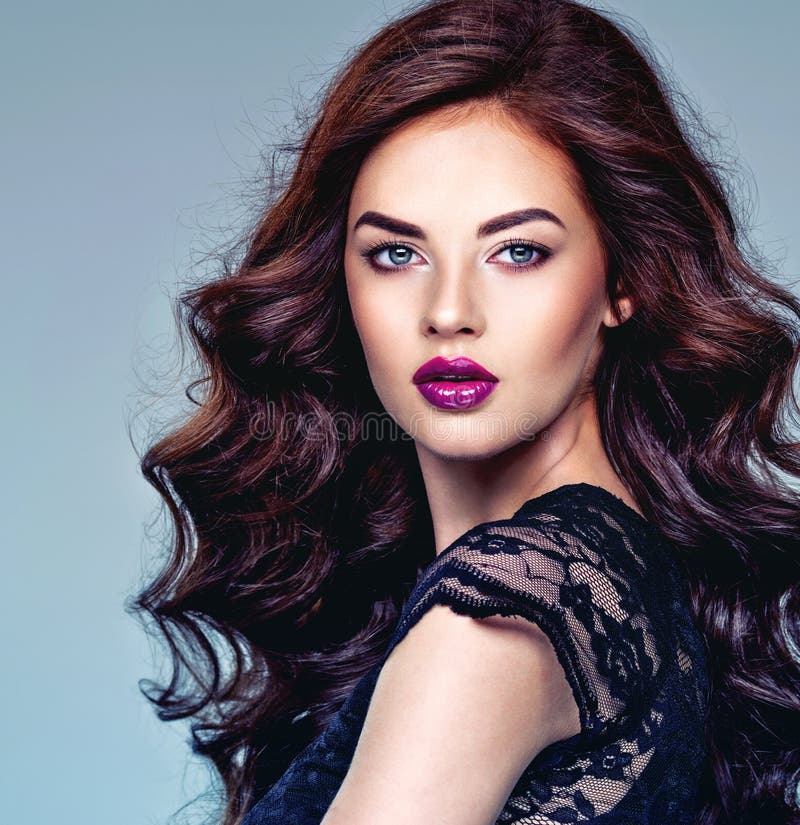 Bella mujer con pelo largo y rizado y maquillaje violeta brillante imagen de archivo libre de regalías