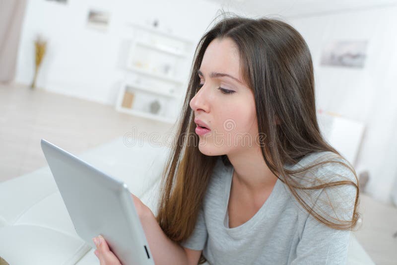 Bella mujer relajándose en el sofá con tablet fotografía de archivo