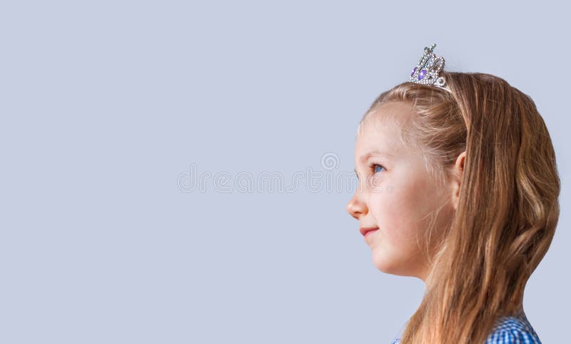 Bella Niña Princesa Con Una Brillante Corona De Plata Sonriendo. Jovencita  Con El Pelo Largo Ondulado En Retrato De Vestir Azul Imagen de archivo -  Imagen de emociones, ropa: 195070445