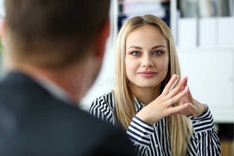 Bella persona femminile bionda che si siede al ritratto del posto di lavoro fotografia stock Bella persona femminile bionda che si siede al ritratto del posto di lavoro fotografia stock