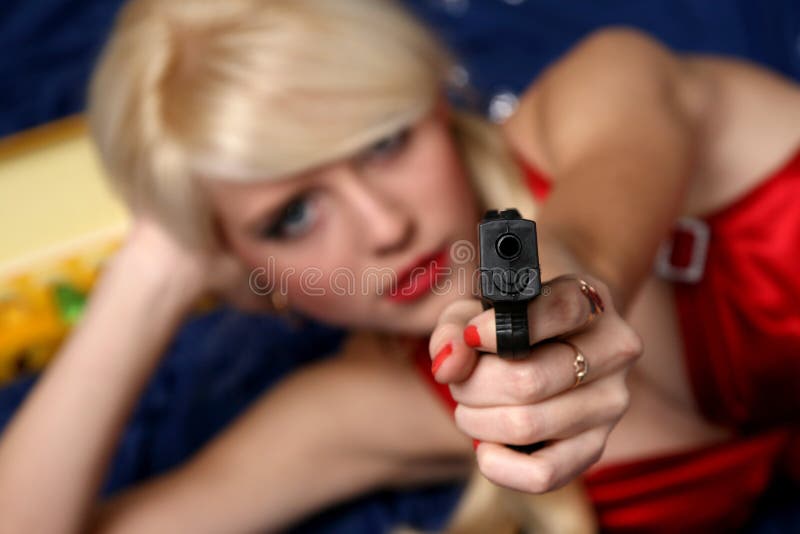 Bella pistola della holding della giovane donna, fuoco sulla pistola immagini stock libere da diritti Bella pistola della holding della giovane donna, fuoco sulla pistola immagini stock libere da diritti