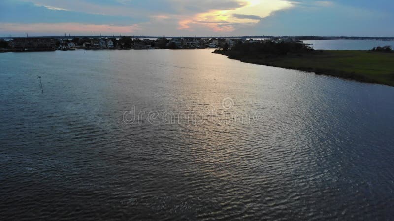 Bella puesta de sol en el océano con reflejos de nubes saturadas en la costa del agua