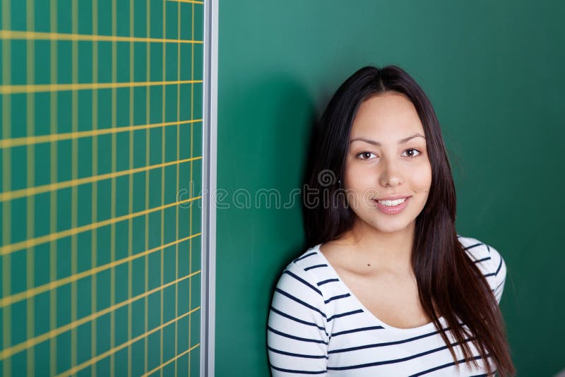 Bella ragazza asiatica che pende contro la lavagna immagini stock libere da diritti Bella ragazza asiatica che pende contro la lavagna immagini stock libere da diritti