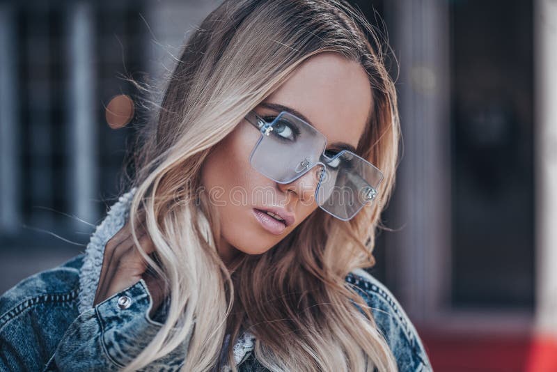 Bella ragazza bionda nei sunglassses blu all'aperto fotografia stock Bella ragazza bionda nei sunglassses blu all'aperto fotografia stock