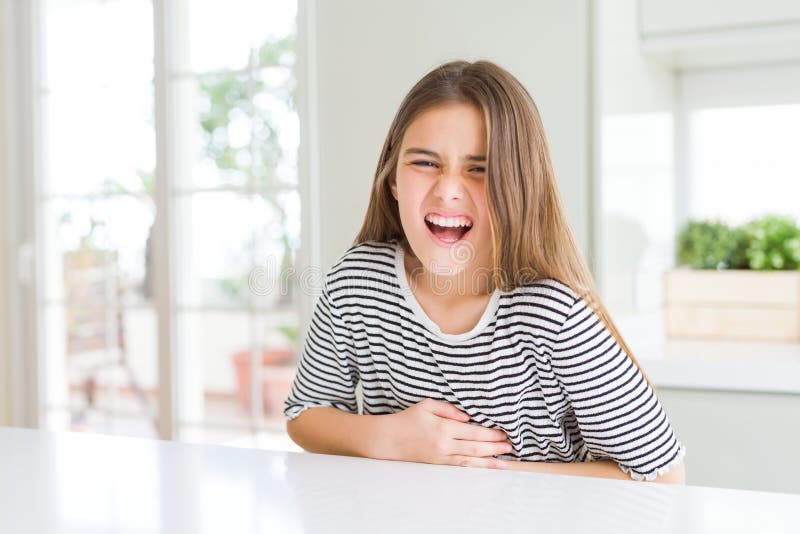 Bella ragazza che indossa una camicia a strisce con la mano sullo stomaco perché l'indigestione dolorosa la malattia si sente male fotografia stock