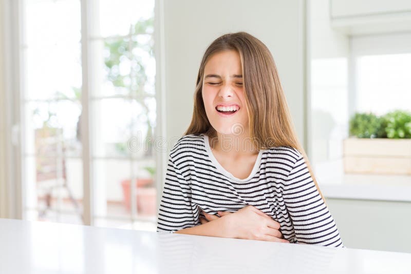 Bella ragazza che indossa una camicia a strisce con la mano sullo stomaco perché la nausea è una malattia dolorosa che si sente ma immagine stock libera da diritti