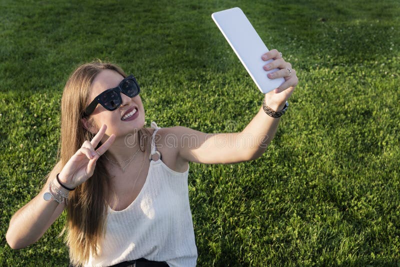 Bella ragazza che prende un selfie nel parco fotografia stock Bella ragazza che prende un selfie nel parco fotografia stock