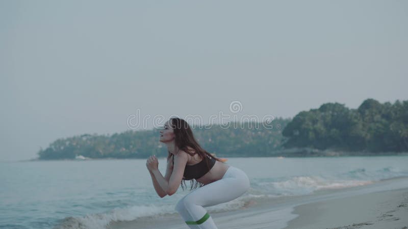 Bella ragazza che si esercita sulla spiaggia sabbiosa video d archivio